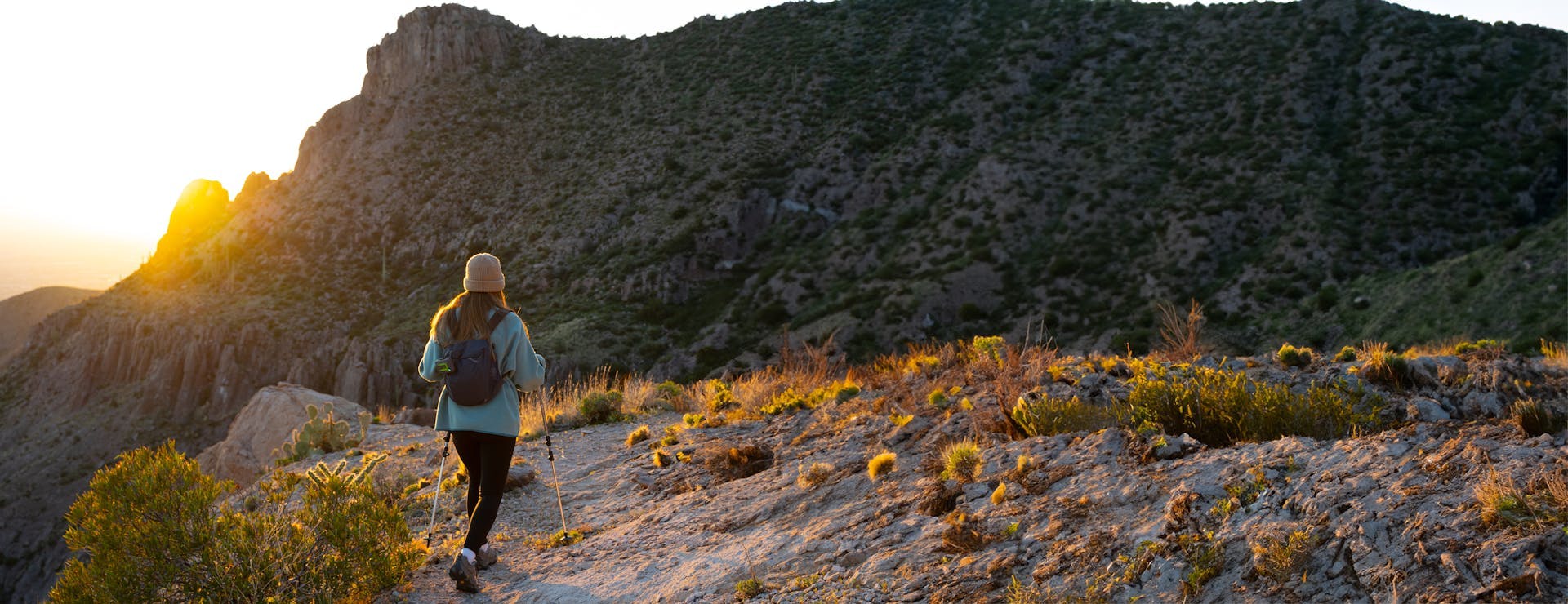 Woman hiking in mountains at sunset