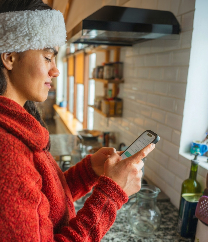 A woman checking her smartphone at home
